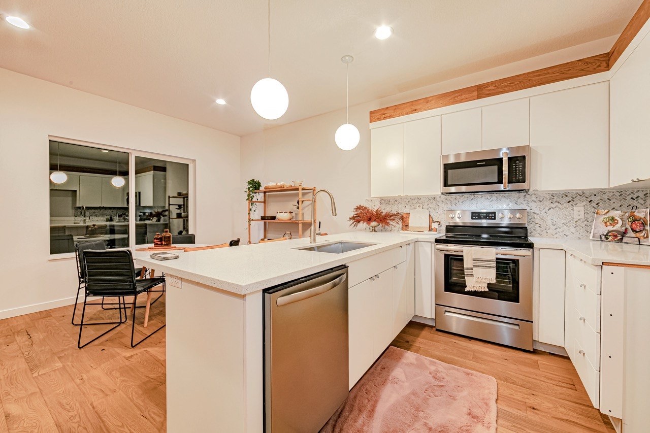 Bright kitchen with a white island and oak stools